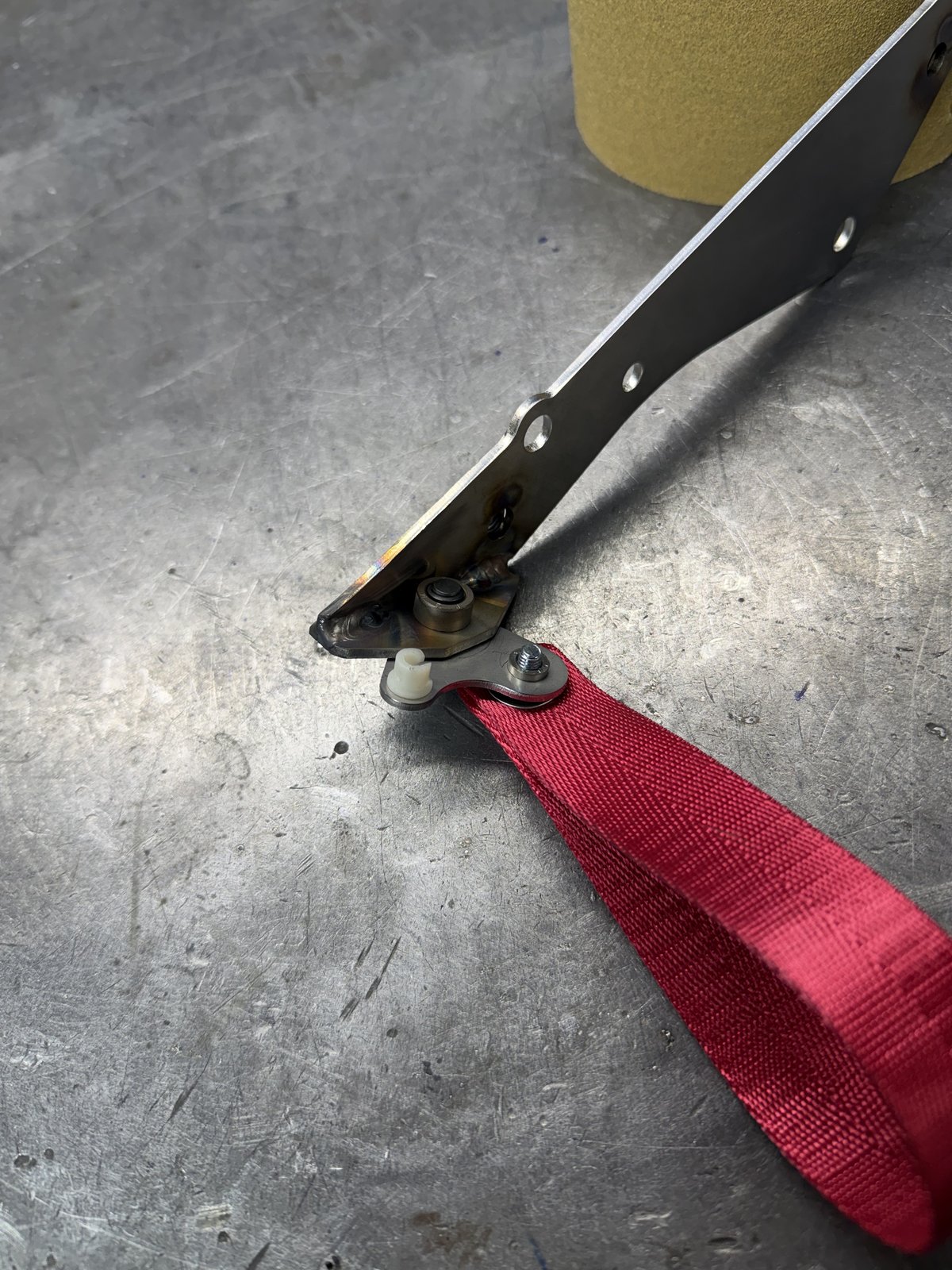 Prototype harness mount bracket with safety strap